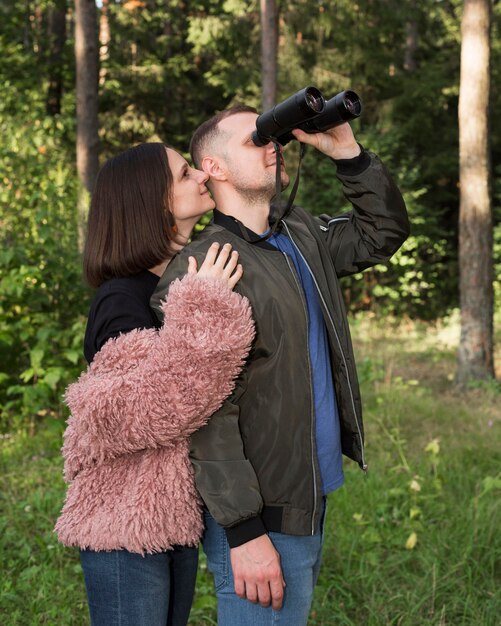 Widok z boku człowieka oglądającego przez lornetkę