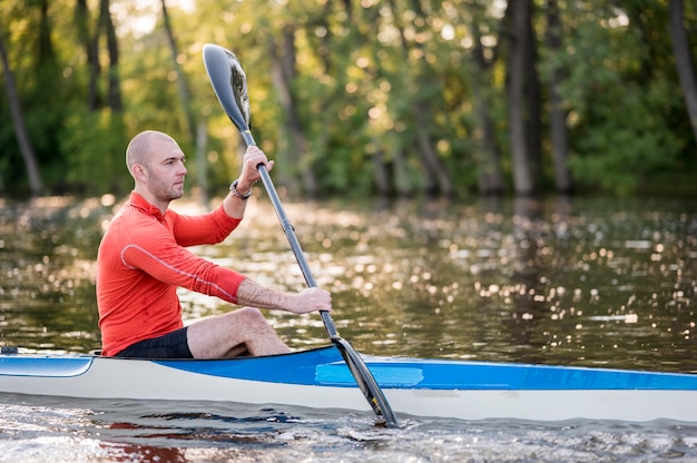 Widok z boku człowieka w canoe z wiosła