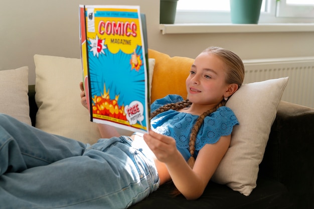 Widok z boku dziewczyna czytająca komiksy w pomieszczeniu