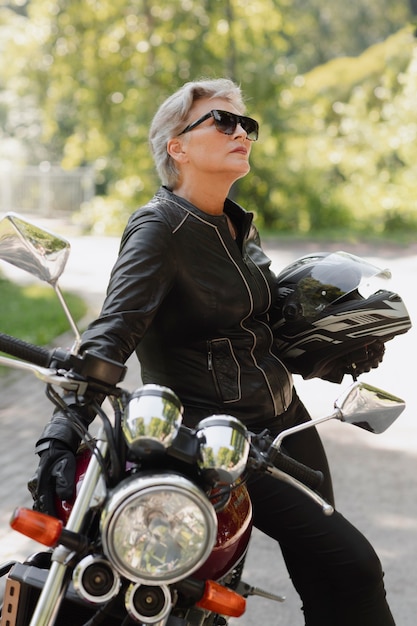 Bezpłatne zdjęcie widok z boku fajna stara kobieta z motocyklem
