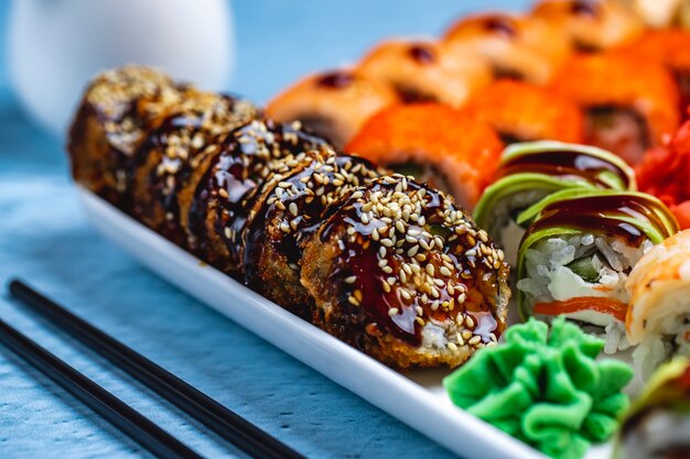 Widok z boku gorąco roll smażone sushi roll z sosem teriyaki sezamem i imbirem na talerzu