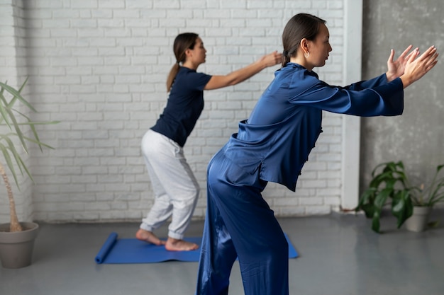 Bezpłatne zdjęcie widok z boku kobiet ćwiczących tai chi