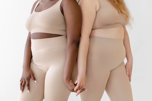Bezpłatne zdjęcie widok z boku kobiet stwarzających podczas noszenia urządzenia do modelowania sylwetki