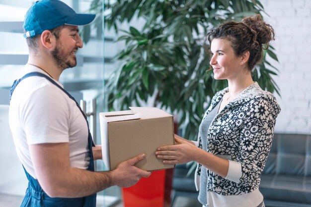 Widok z boku kobieta biorąc paczkę od deliveryman