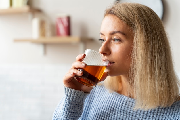 Bezpłatne zdjęcie widok z boku kobieta pijąca kombucha