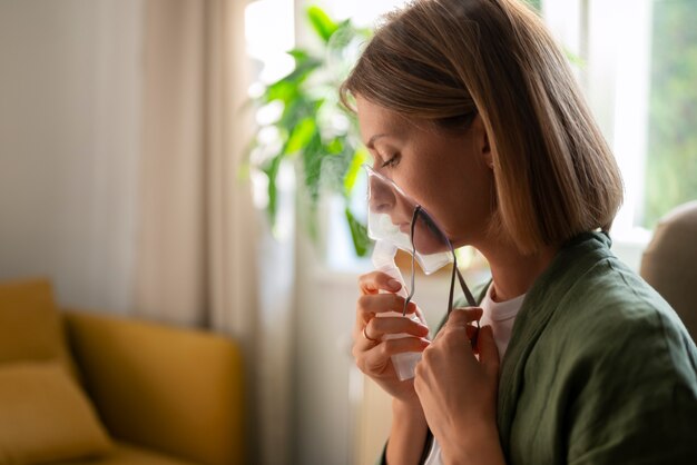 Widok z boku kobieta używająca nebulizatora