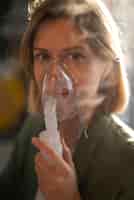 Bezpłatne zdjęcie widok z boku kobieta używająca nebulizatora