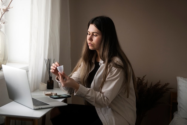 Widok z boku kobiety trzymającej kubek menstruacyjny