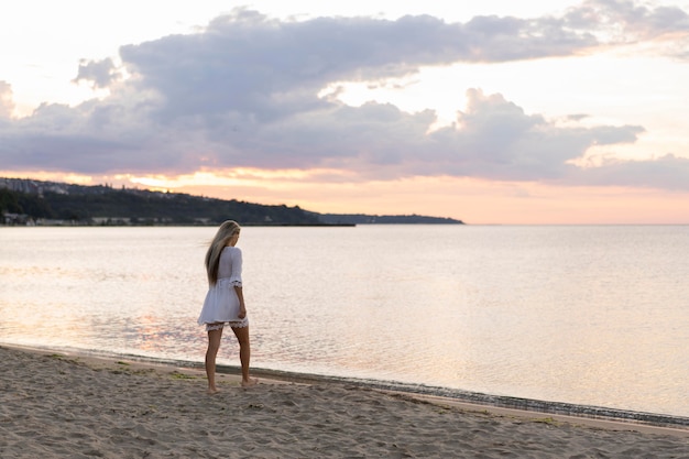 Widok z boku kobiety z widokiem na plażę