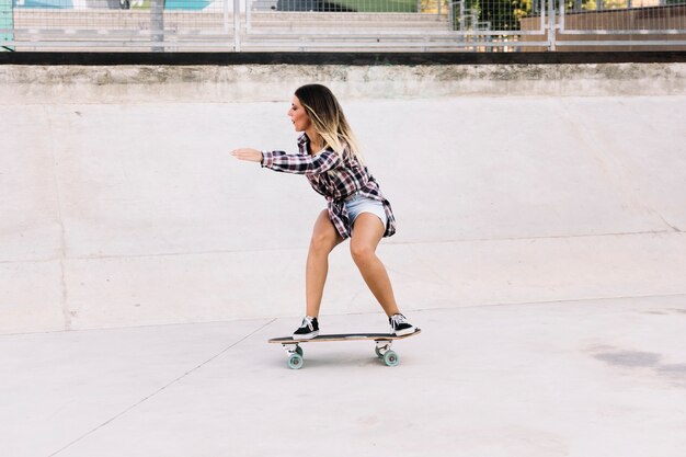 Widok z boku łyżwiarka dziewczyna na skateboard
