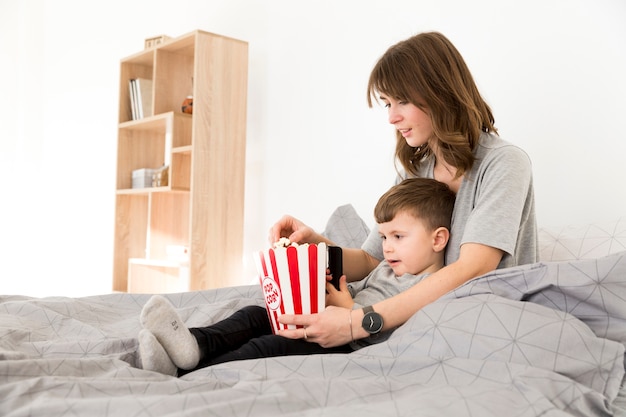 Widok z boku mama i syn jedzenie popcornu