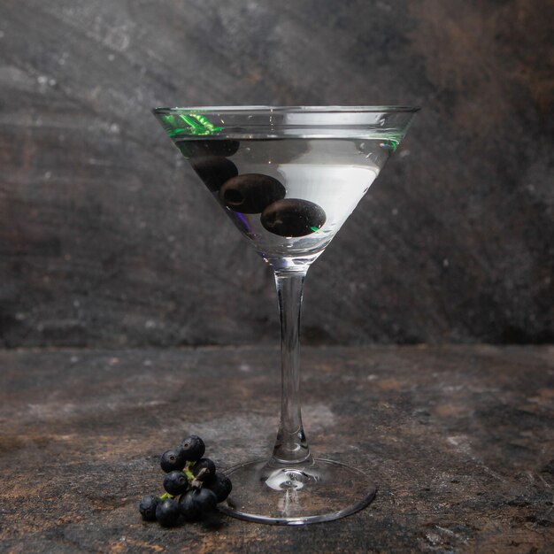 Widok z boku martini w szklance z oliwkami
