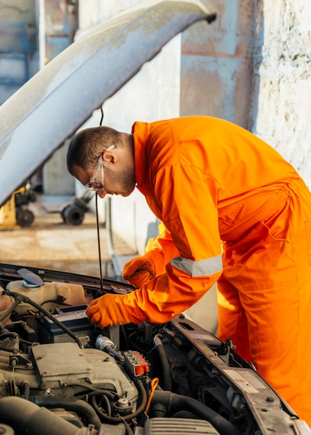 Widok z boku mechanika w okularach ochronnych i mundurze