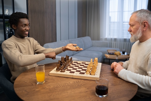 Widok z boku mężczyzn grających w szachy w pomieszczeniu