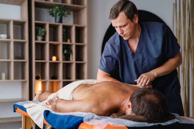 Bezpłatne zdjęcie widok z boku mężczyzna otrzymujący profesjonalny masaż