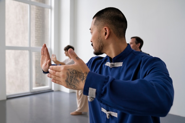 Bezpłatne zdjęcie widok z boku osób ćwiczących tai chi