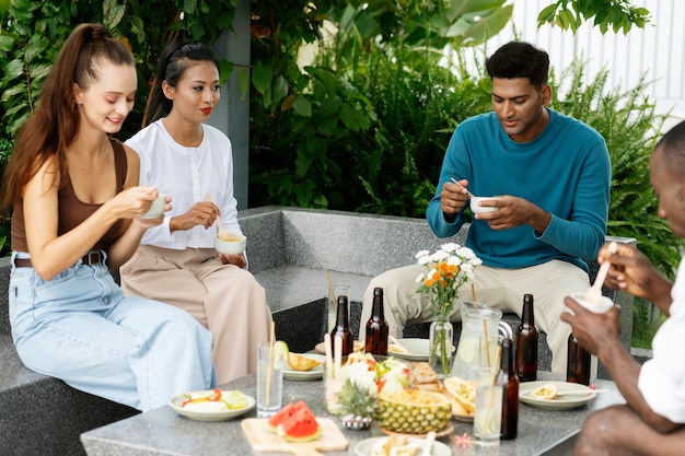Bezpłatne zdjęcie widok z boku osób jedzących na imprezie zewnętrznej?