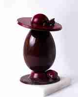 Bezpłatne zdjęcie widok z boku ozdobiony czekoladowym jajkiem z kapeluszem i czekoladowym sercem na stojaku