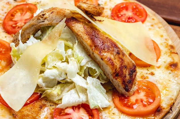 Widok z boku pizza Cezar z grillowanym kurczakiem Pomidorowy ser parmezan i sałata na desce