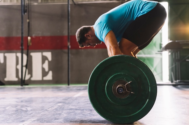 Widok z boku pojęcia bodybuilding z mężczyzną w koszulce