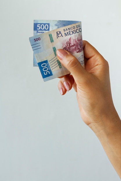Widok z boku ręki trzymającej banknot