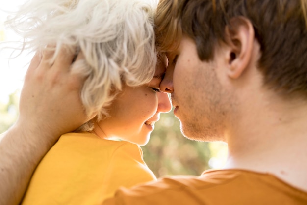 Widok z boku romantycznej pary na świeżym powietrzu w parku