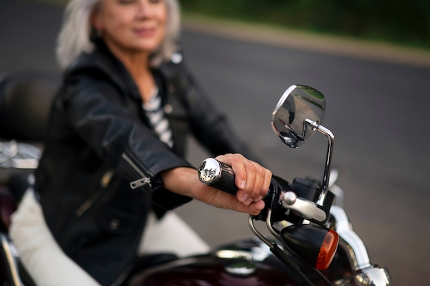 Bezpłatne zdjęcie widok z boku starsza kobieta z motocyklem