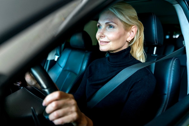 Widok z boku starszej kobiety biznesu jazdy samochodem