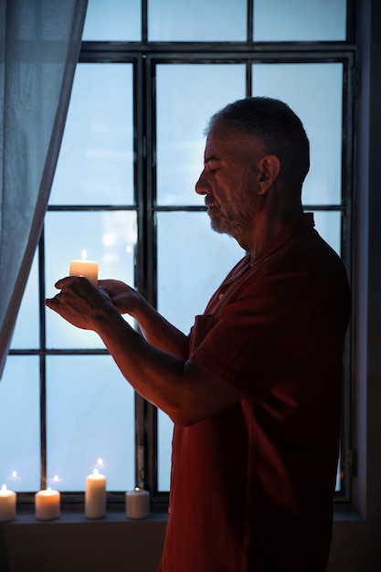 Widok z boku starszy mężczyzna trzyma świecę