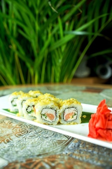 Widok z boku tradycyjnej japońskiej kuchni sushi roll z tuńczykiem podawane z imbirem na zielono