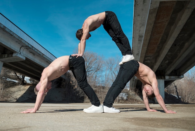 Bezpłatne zdjęcie widok z boku trzech bez koszuli hip-hopowych artystów ćwiczących rutynę taneczną