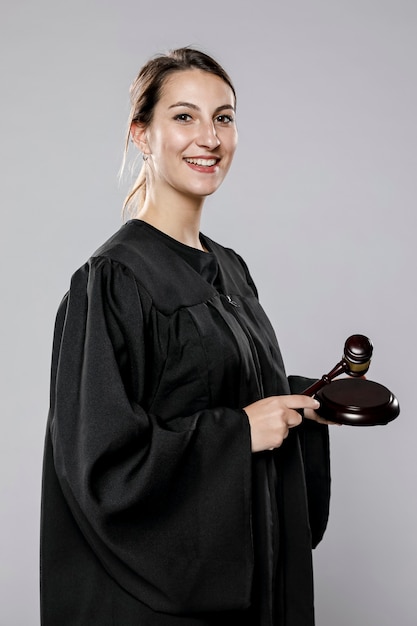 Widok z boku uśmiechniętej kobiety sędzia z młotkiem