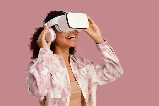 Widok z boku uśmiechniętej kobiety z zestawem słuchawkowym wirtualnej rzeczywistości
