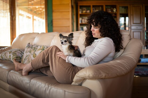 Widok z boku właściciela siedzącego na kanapie z psem