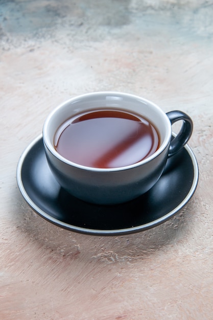 Widok z boku z bliska filiżanka herbaty filiżanka herbaty na czarnym spodku