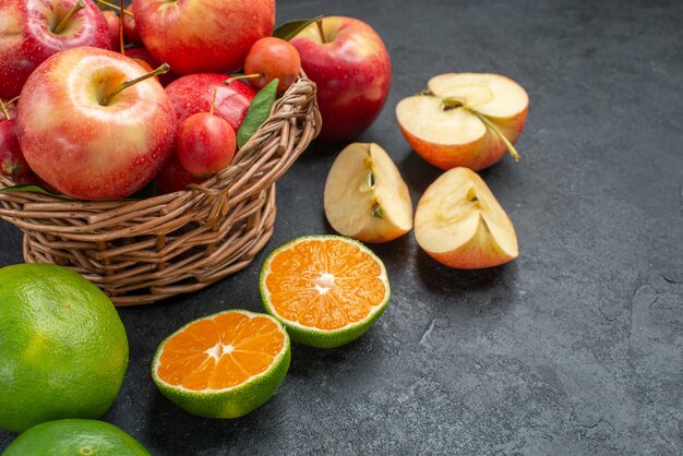 Widok z boku z bliska owoce drewniany kosz jabłek i wiśni owoce cytrusowe jabłka