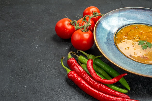 Widok z boku z bliska zupa z soczewicy zupa z soczewicy apetyczne pomidory z szypułkami ostra papryka