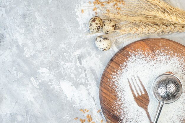 Widok z góry biała mąka w kształcie łyżki i widelca na jasnym stole ciasto słodkie jajka cukier herbata sztućce herbatniki pieczenie ciasta wolne miejsce