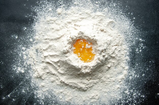Widok z góry biała mąka zmieszana z jajkiem na ciemnym tle praca cukiernicza ciasto jajeczne ciasto piekarnia pracownik kuchni
