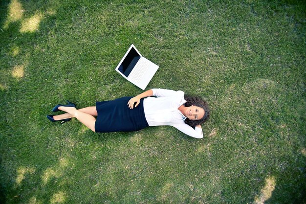 Widok z góry businesswoman leżącego na trawie