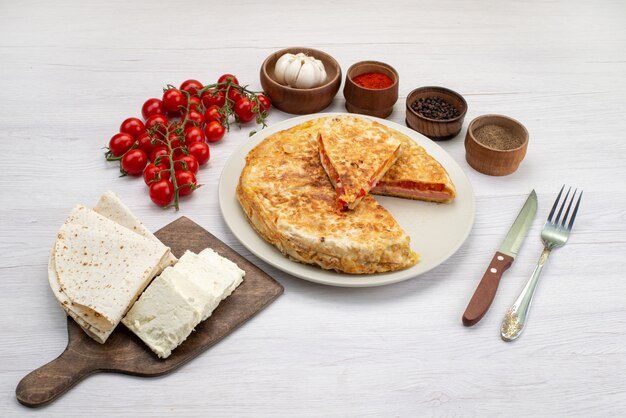Widok z góry ciasto z warzywami wraz z białym serem i świeżymi pomidorami na białym tle zdjęcie obiadowe jedzenie