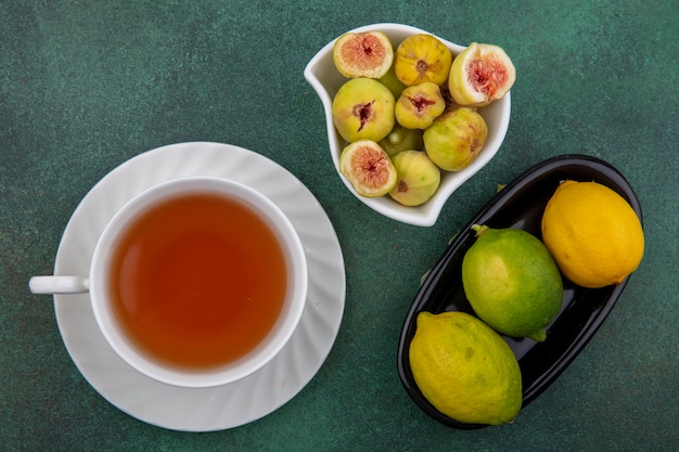 Widok Z Góry Filiżanka Herbaty Z Figami I Limonkami I Cytryną Na Zielonym Tle
