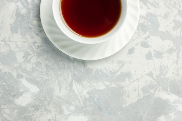 Widok z góry filiżankę gorącego napoju herbaty na jasnobiałej powierzchni