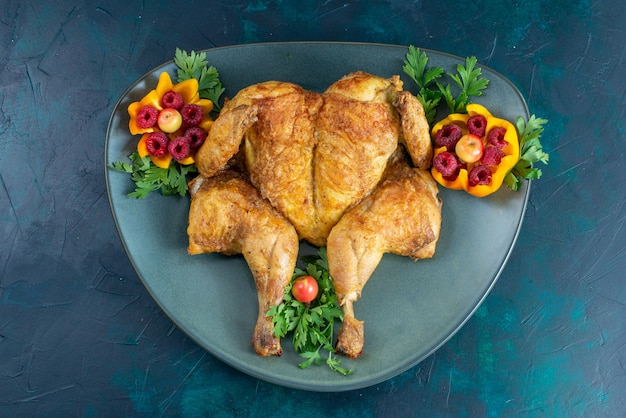 Bezpłatne zdjęcie widok z góry gotowanego kurczaka z zieleniną wewnątrz talerza na ciemnoniebieskim biurku mięso kurczaka jedzenie obiad mięso