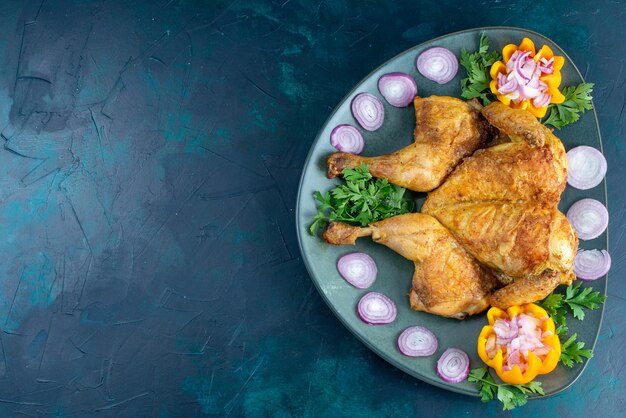 Widok z góry gotowanego kurczaka z zieleniną wewnątrz talerza na ciemnoniebieskim biurku mięso z kurczaka na obiad