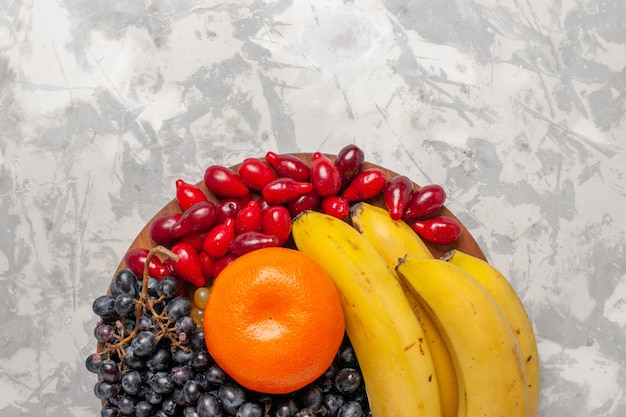 Bezpłatne zdjęcie widok z góry kompozycja świeżych owoców banany derenie i winogrona na białej powierzchni owoce jagodowa świeżość witamina