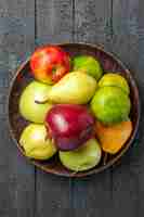 Bezpłatne zdjęcie widok z góry kompozycja świeżych owoców jabłka gruszki i mandarynki wewnątrz talerza na ciemnoniebieskim biurku kolor owoców świeże dojrzałe dojrzałe drzewo