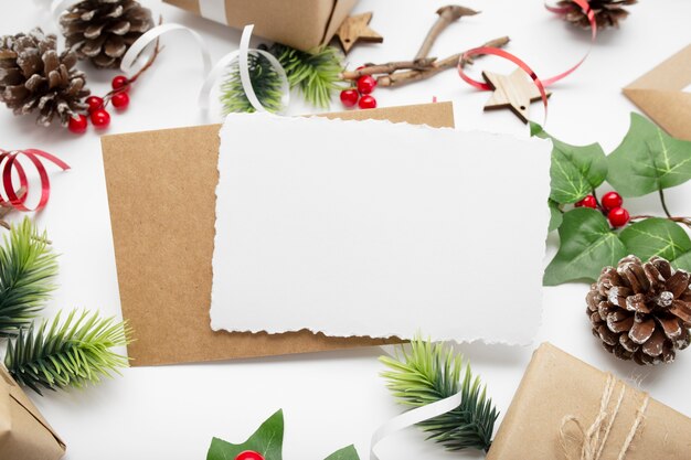 Widok z góry kompozycji świątecznej z pudełkiem, wstążką, gałęziami jodły, szyszkami, anyżem na białym stole