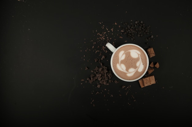 Widok z góry kopia przestrzeń filiżankę cappuccino z czekoladą na czarnym stole
