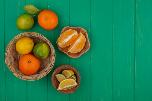 Widok Z Góry Miejsca Kopiowania Obrane Plasterki Pomarańczy W Misce Z Limonki I Cytryny W Koszu Na Zielonym Tle